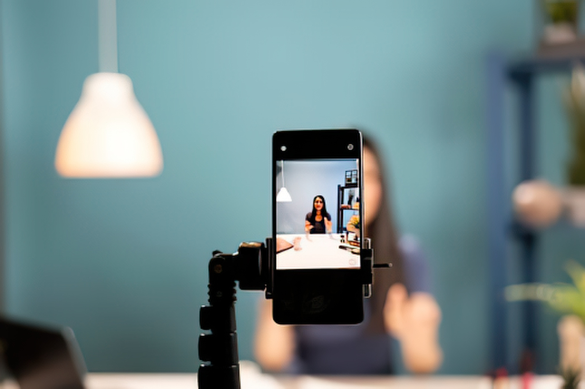 Person filming selfie with smartphone on tripod
